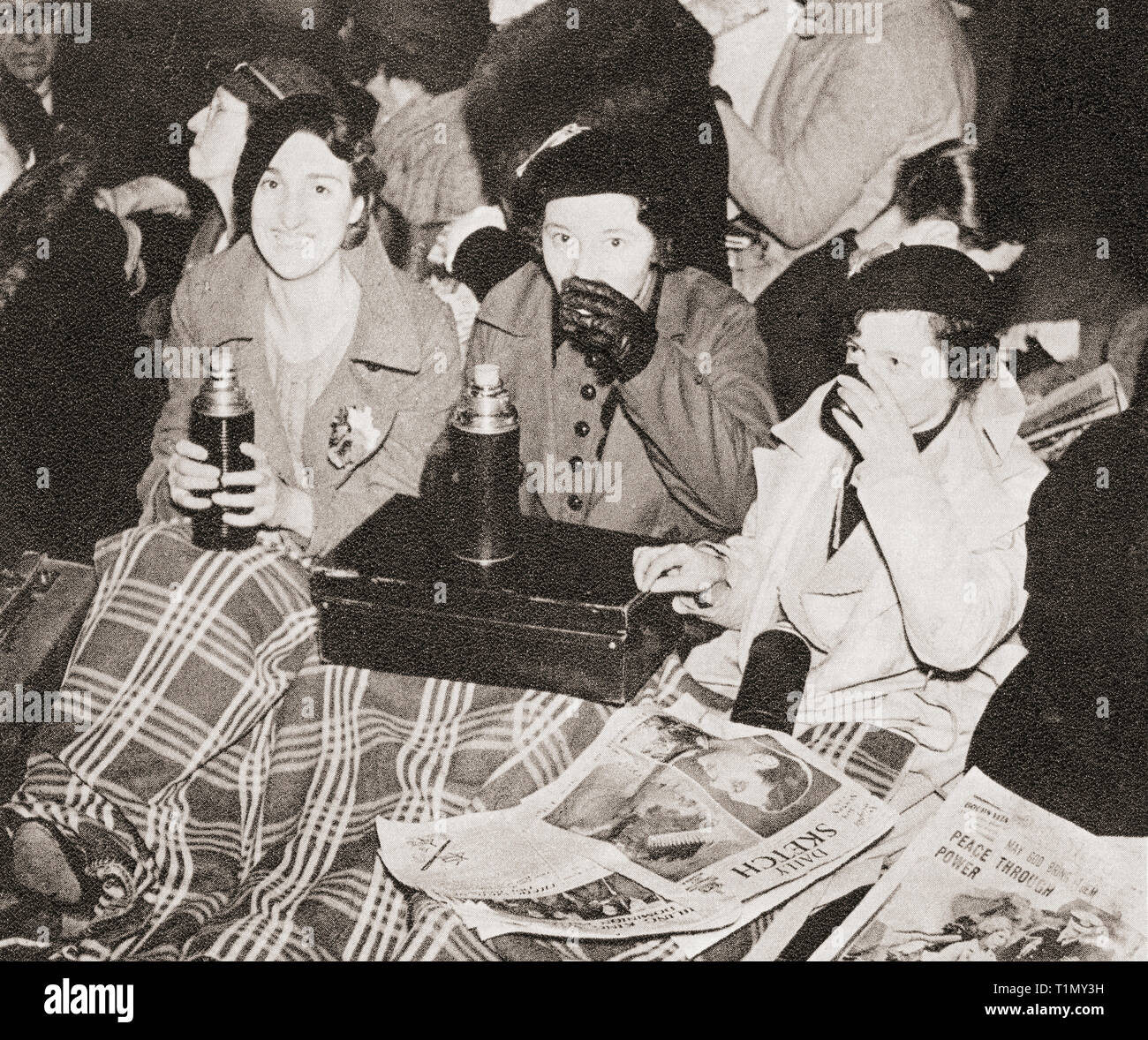 Trois femmes ont une tasse de thé du matin à Piccadilly Circus, Londres, Angleterre en attendant la Procession du couronnement de George VI et la reine Elizabeth en 1936. Du couronnement en images, publié 1937. Banque D'Images