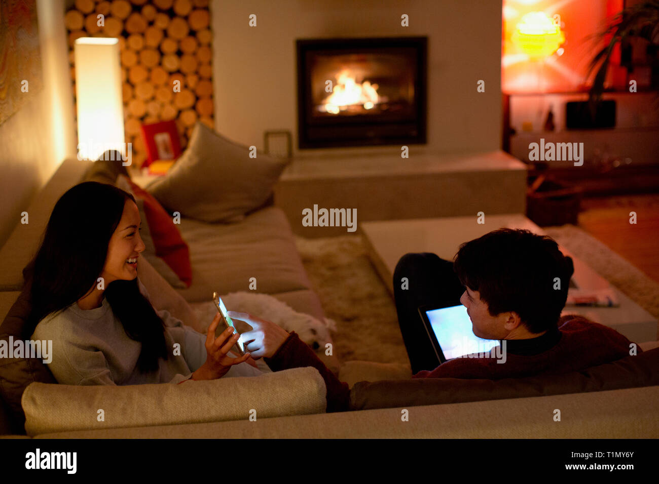 Couple à l'aide de smart phone et digital tablet in the living room Banque D'Images