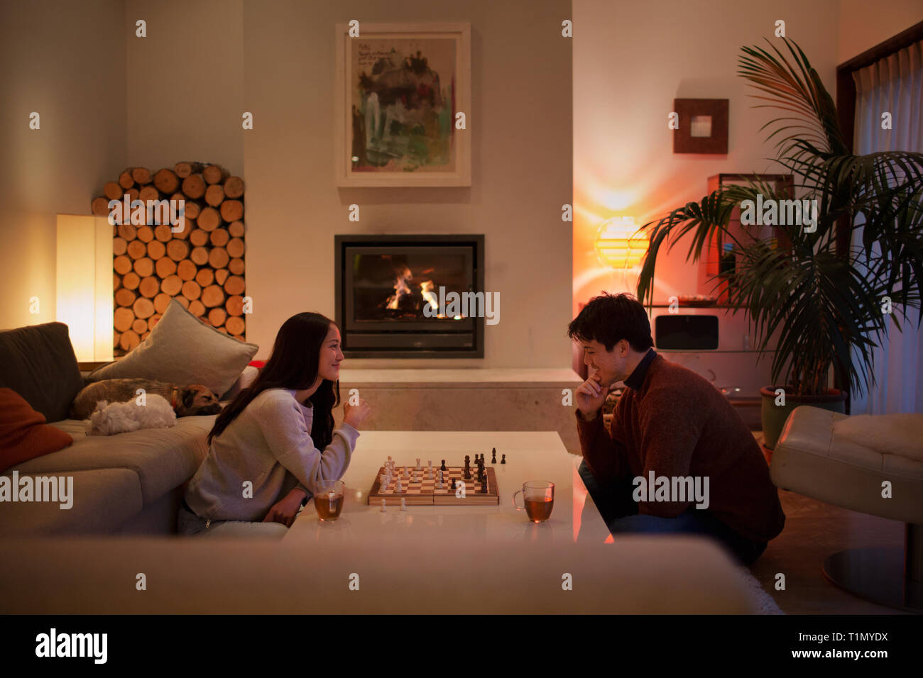 Couple jouant aux échecs dans la salle de séjour Banque D'Images