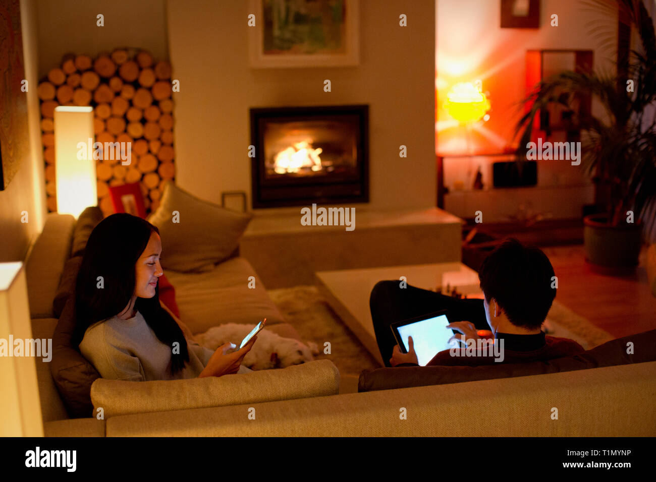 Couple et smart phone in living room Banque D'Images