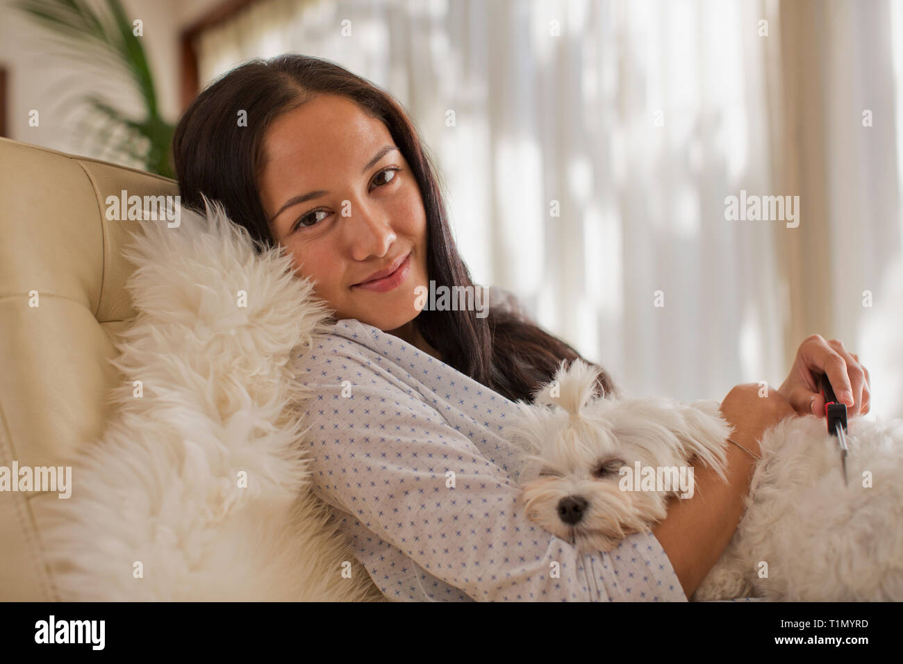 Portrait of smiling young woman cuddling with dog Banque D'Images