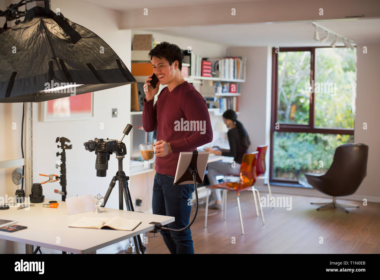 Homme photographe travaillant en studio, pause café Banque D'Images