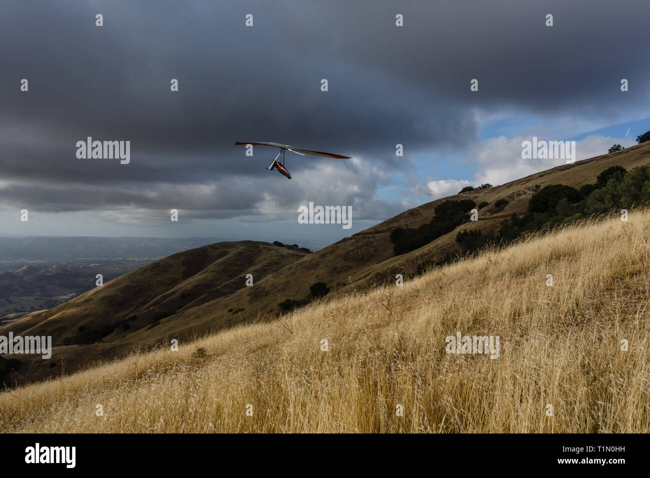 Planeur décolle au-dessus de collines herbeuses mt Diablo ci-dessous des nuages de tempête sombre Banque D'Images