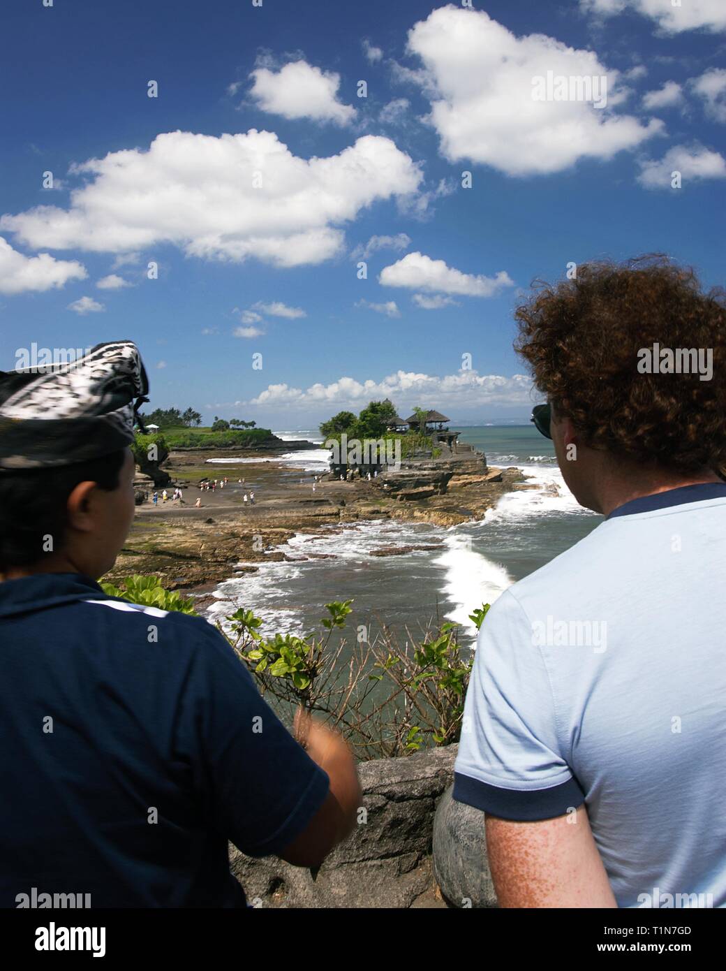 Un guide balinais est en train de parler à un touriste à propos de temple de Tanah Lot. Lieu : Bali, Indonésie. Banque D'Images