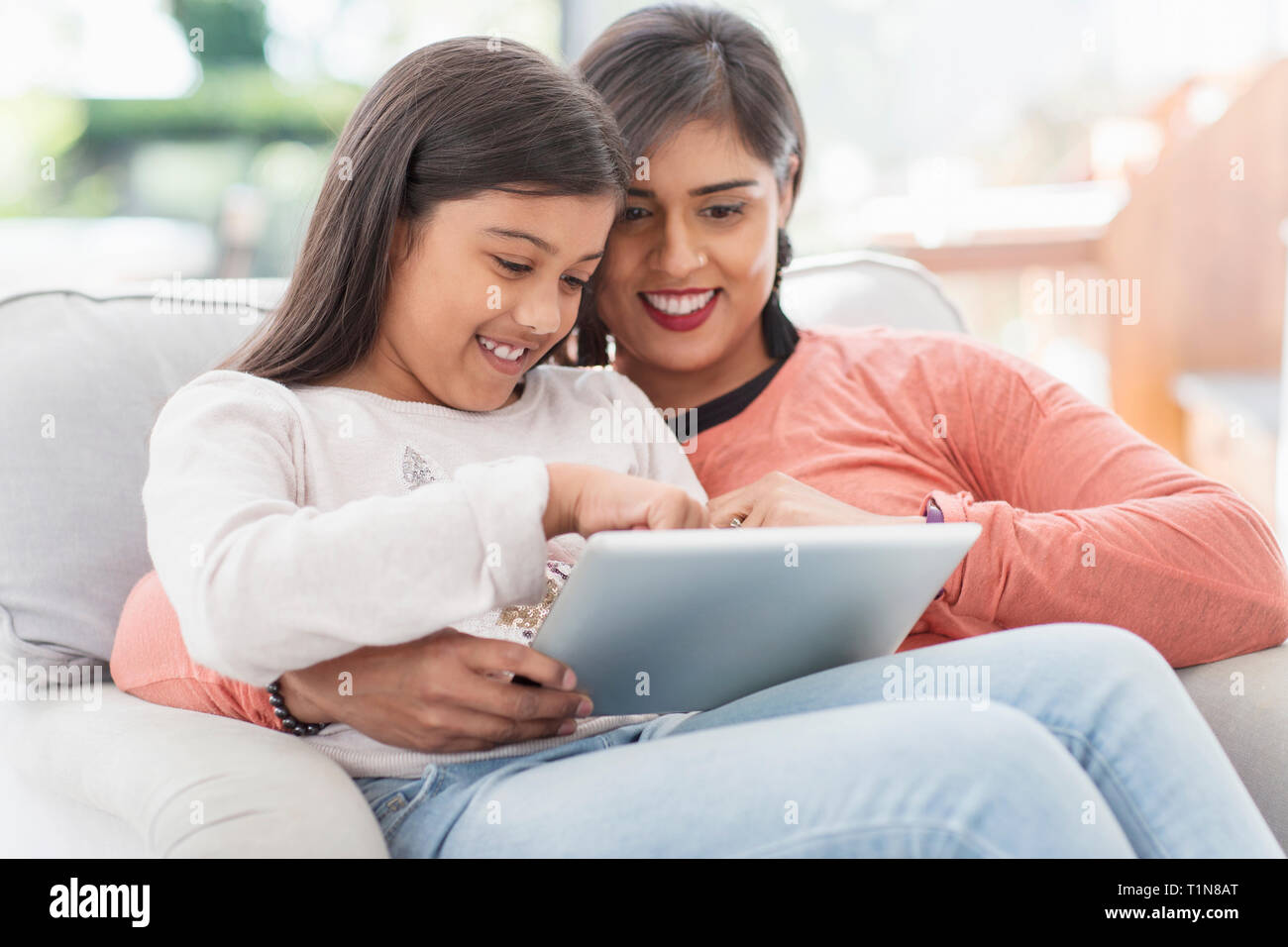 Happy mother and daughter using digital tablet Banque D'Images