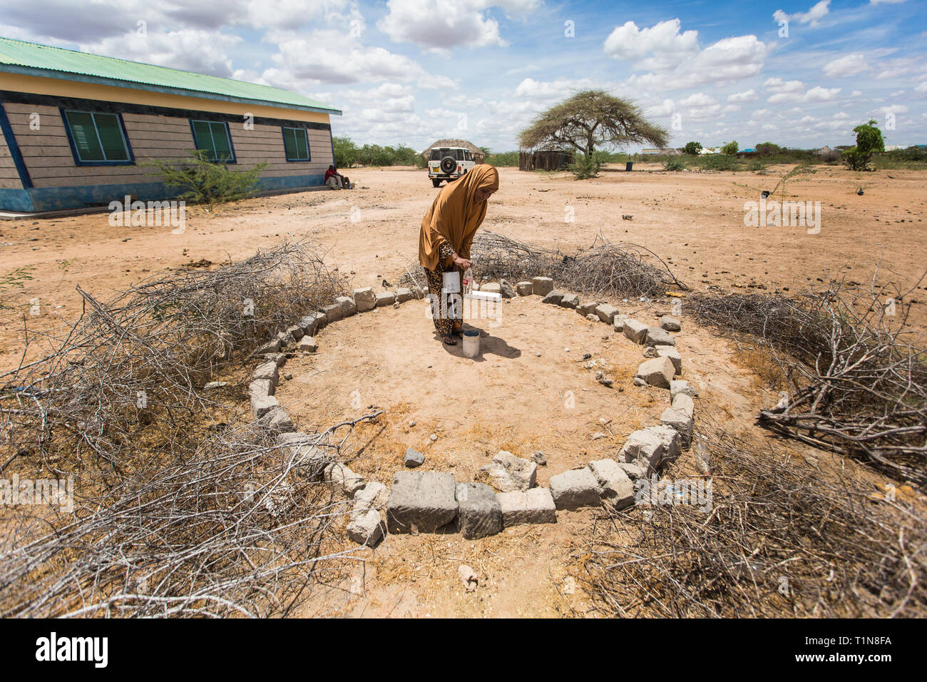 Une femme vérifie un pluviomètre dans son village d'Nanighi, situé dans le nord-est du Kenya, près de la frontière de la Somalie. Le Kenya, avec beaucoup de pays dans le monde en développement, repose toujours sur des milliers de bénévoles pour aider à enregistrer ce que il pleut. Banque D'Images