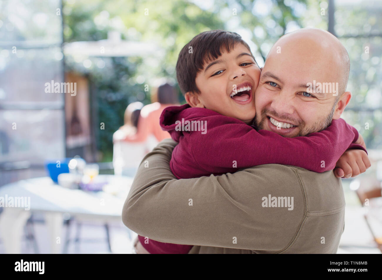 Heureux, père et fils exubérante hugging Banque D'Images