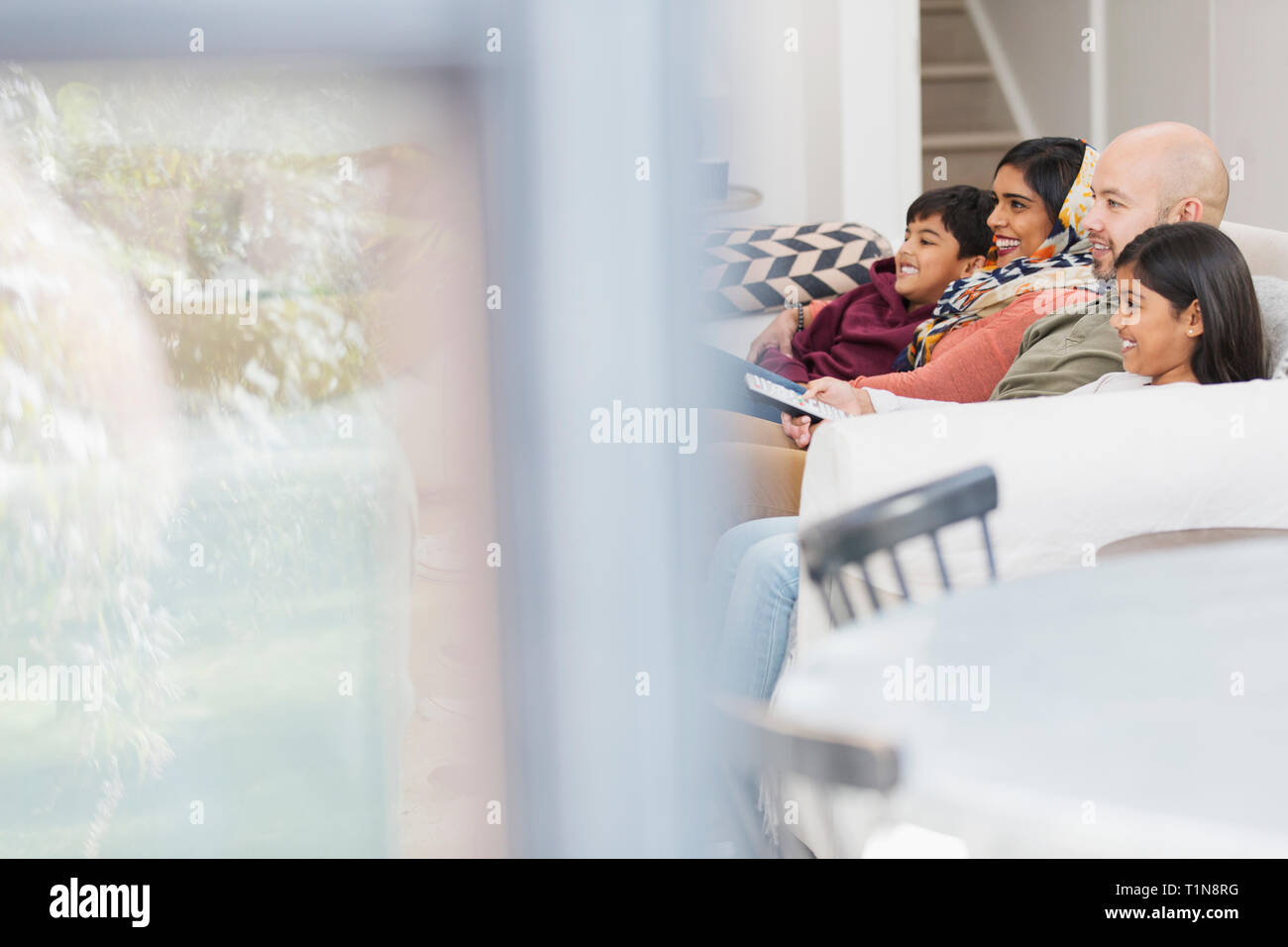 Regarder la télé sur la famille salon canapé Banque D'Images