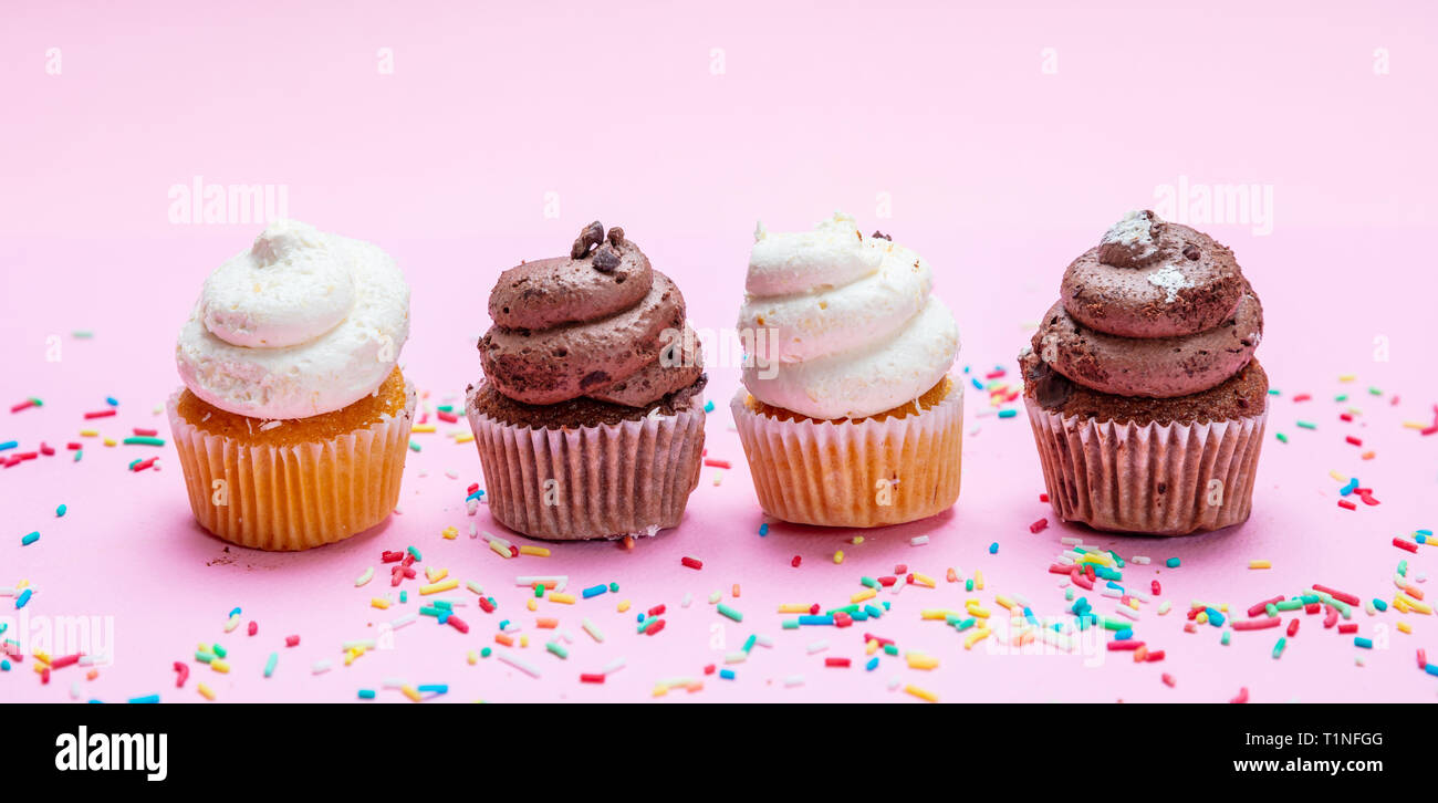Cupcakes sur fond rose. Quatre cupcakes vanille et chocolat, la bannière Banque D'Images