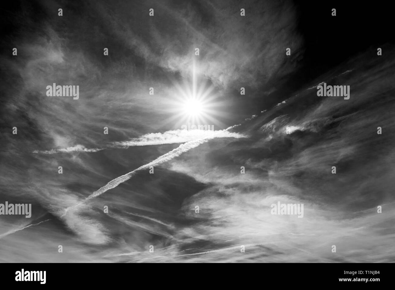 Noir & blanc vue de créer des motifs de traînées de jet contre ciel bleu cobalt & sun ; centre du Colorado, USA Banque D'Images