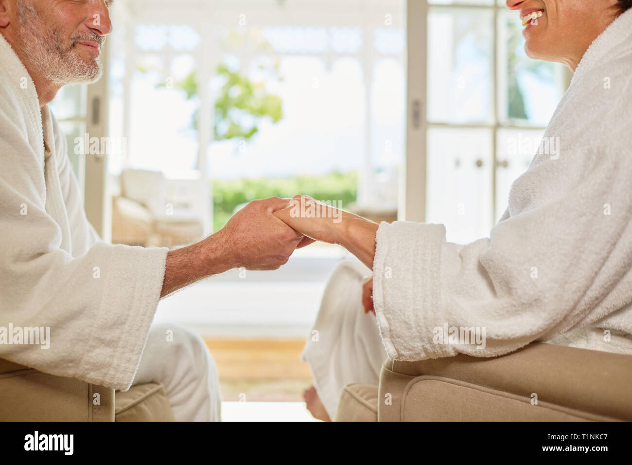 Affectionate couple en tenant les mains de peignoirs spa Banque D'Images