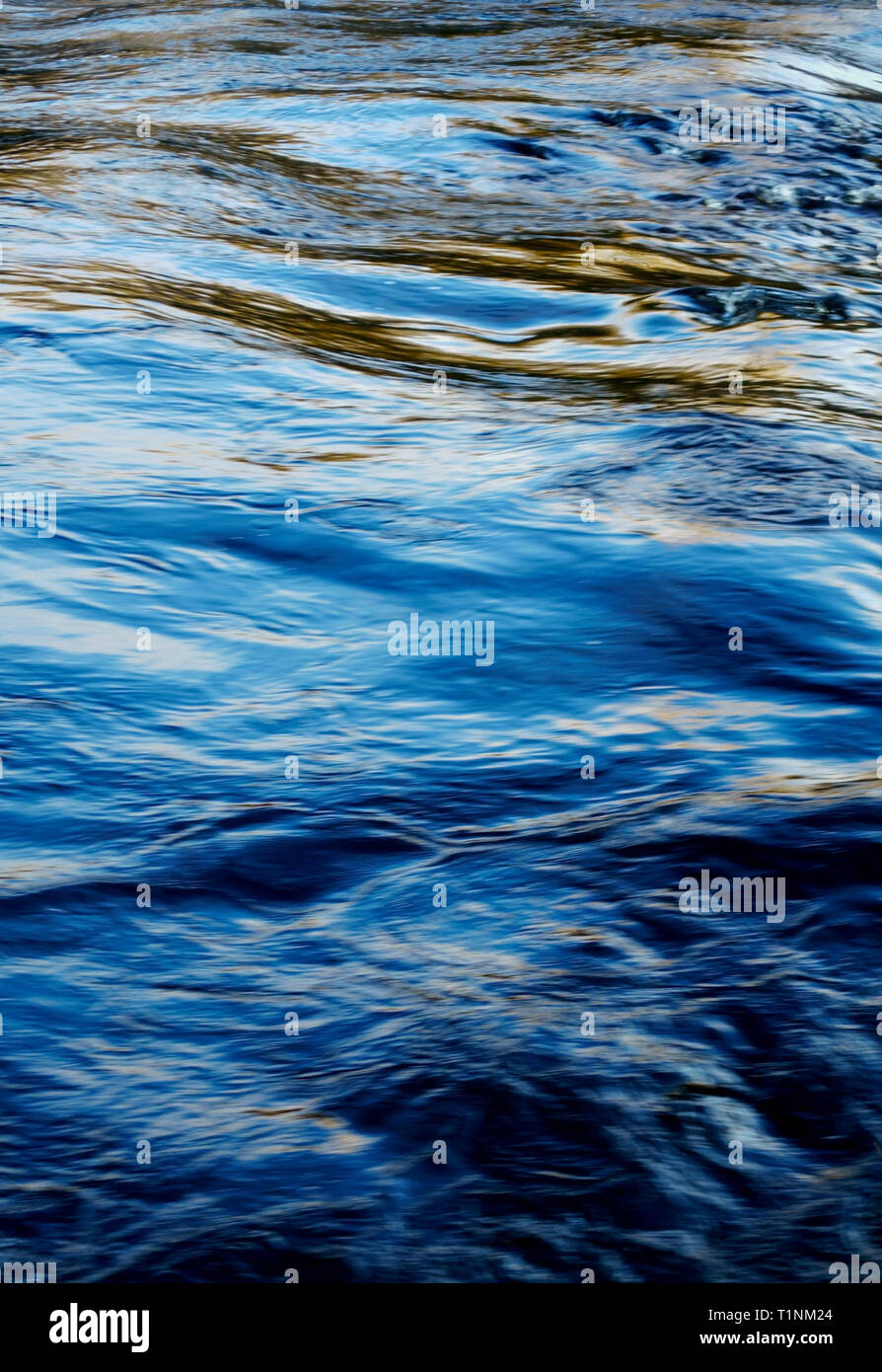 Reflets et ombres sur une rivière sur un ciel bleu ensoleillé jour. Banque D'Images