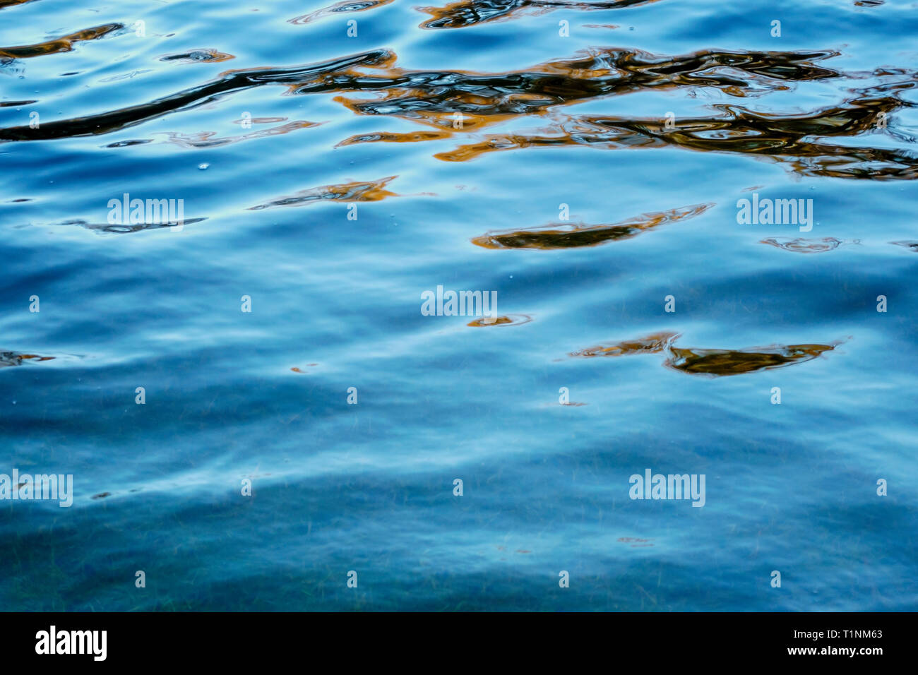 Reflets et ombres sur une rivière sur un ciel bleu ensoleillé jour. Banque D'Images