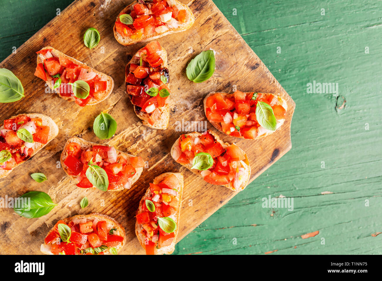 Bruschetta à la tomate, oignon, huile d'olive et le basilic sur planche de bois. Libre. Banque D'Images