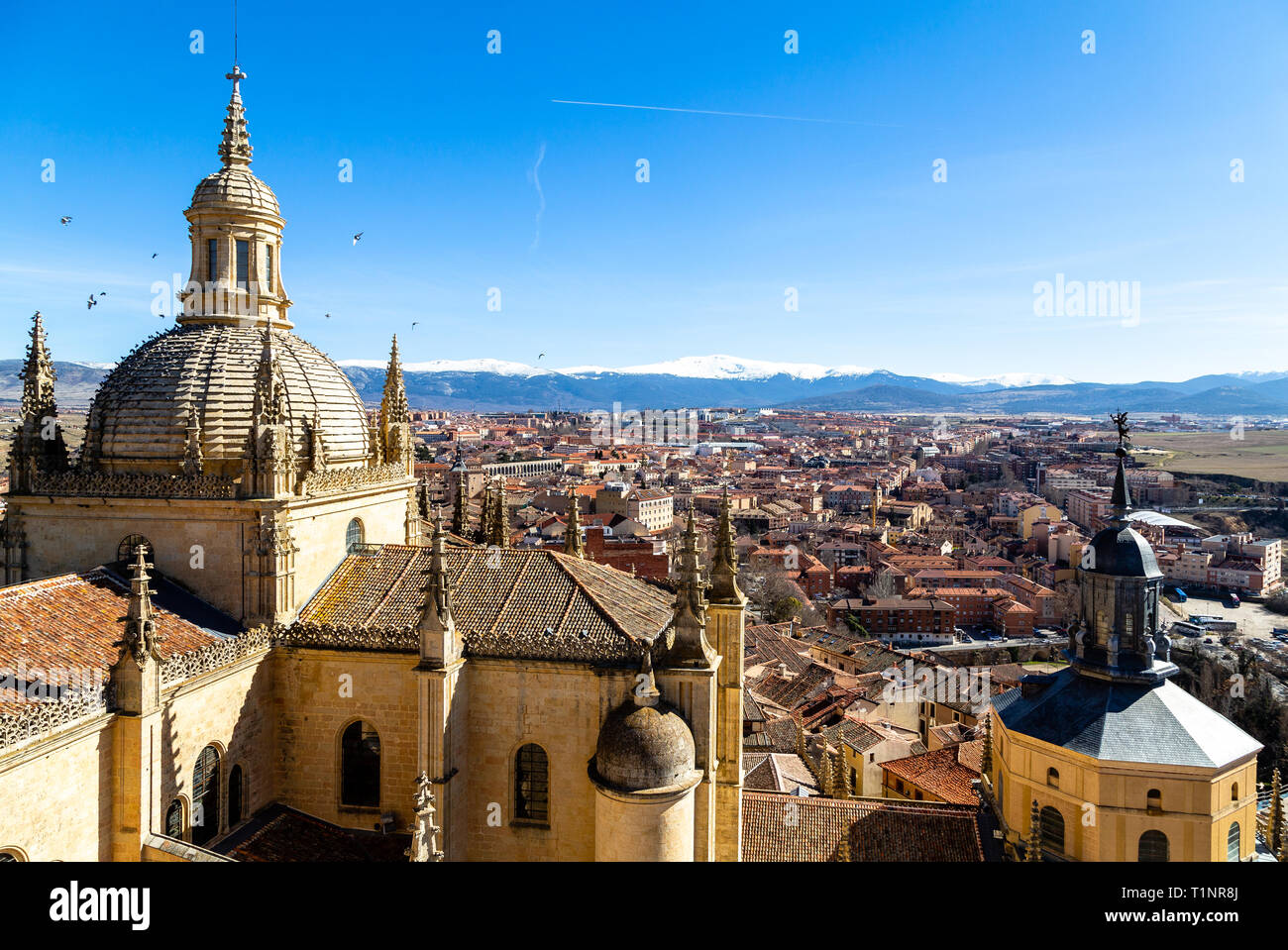 Segovia, Espagne : vue sur le dôme de la cathédrale et de la vieille ville de Ségovie à partir du haut de la tour de cloche en hiver. Les sommets enneigés de Banque D'Images