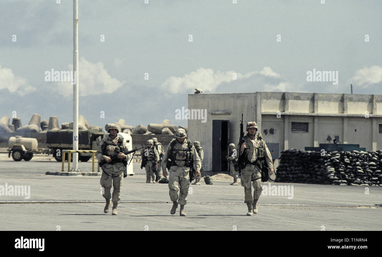 29 octobre 1993 marcher trois en front comme si dans le O.K.Corral, soldats de l'armée américaine de la 24e Division d'infanterie, 1er Bataillon du 64ème Régiment blindé dans le nouveau port de Mogadiscio, Somalie, viennent d'arriver par mer. Banque D'Images