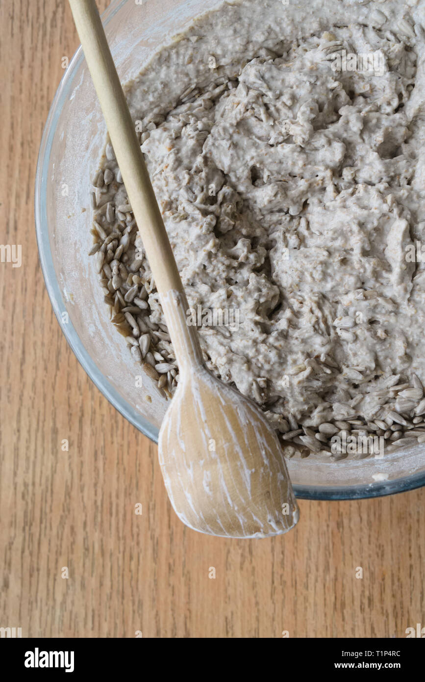 La pâte à pain au levain cru avec graines de tournesol dans un bol en verre sur la cuisine haut. Focus sélectif. Banque D'Images