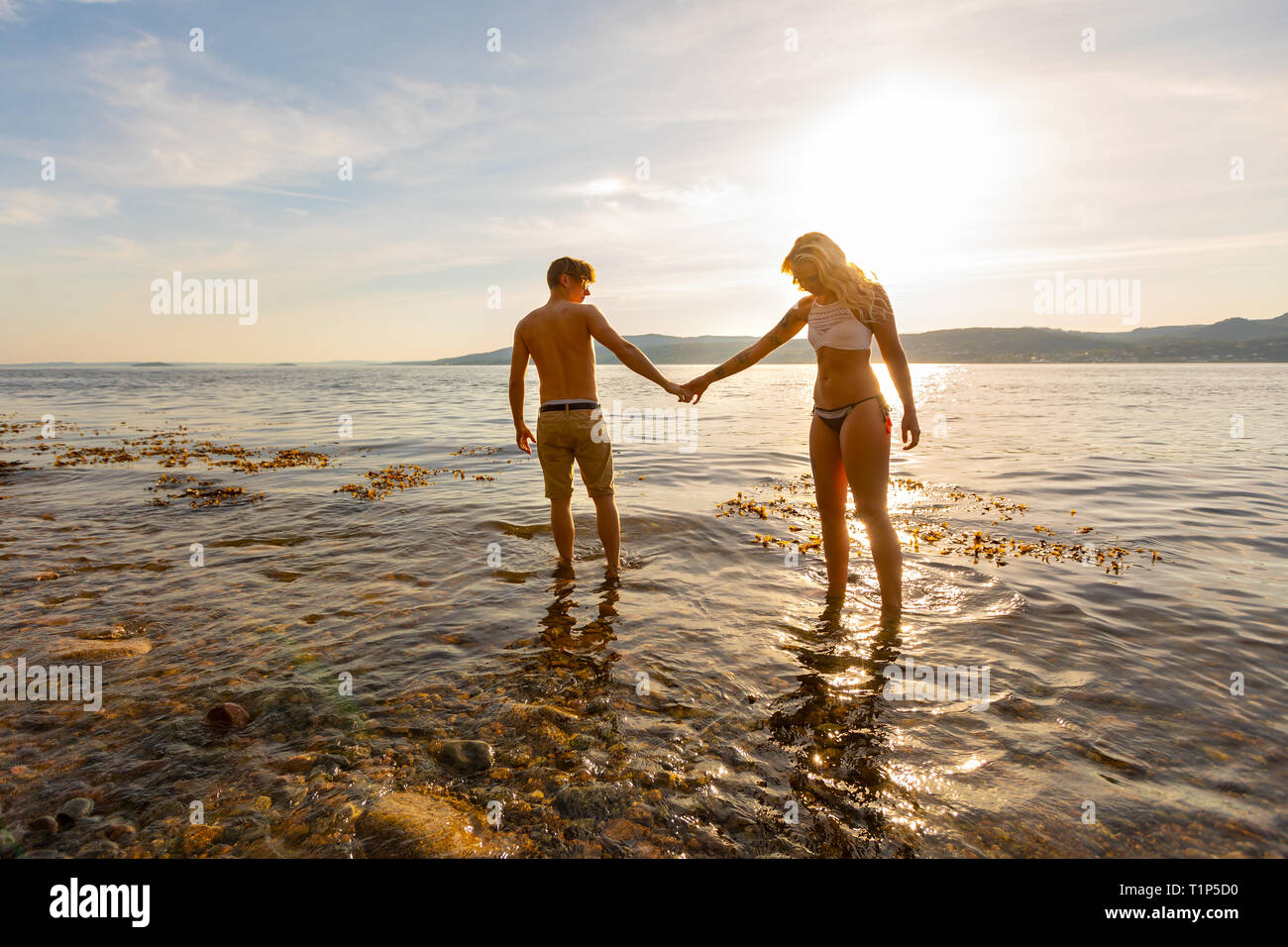 Beau couple holding hands et promenades au bord de la mer dans la soirée Banque D'Images
