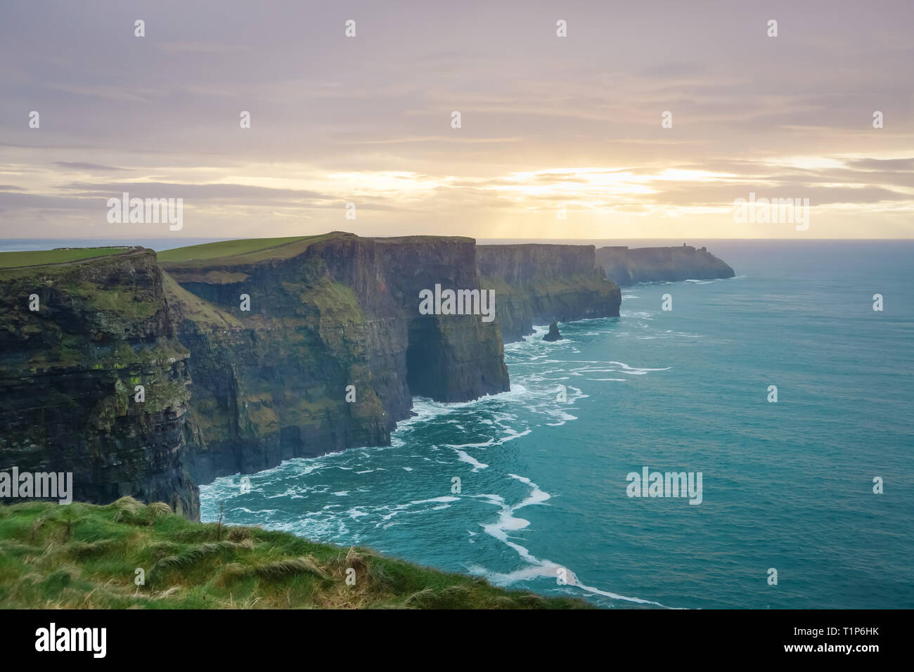 Falaises de Moher emblématique de façon sauvage de l'Atlantique avec de belles vagues et coucher de soleil spectaculaire sur l'océan turquoise Banque D'Images