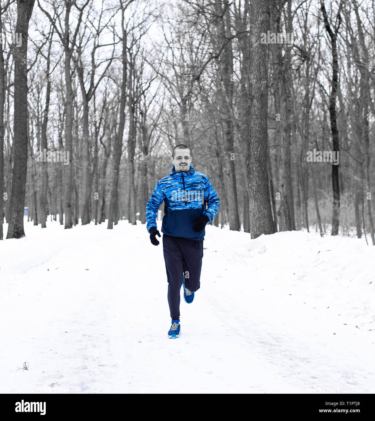 L'homme en forêt d'hiver runner portée en veste bleue Banque D'Images