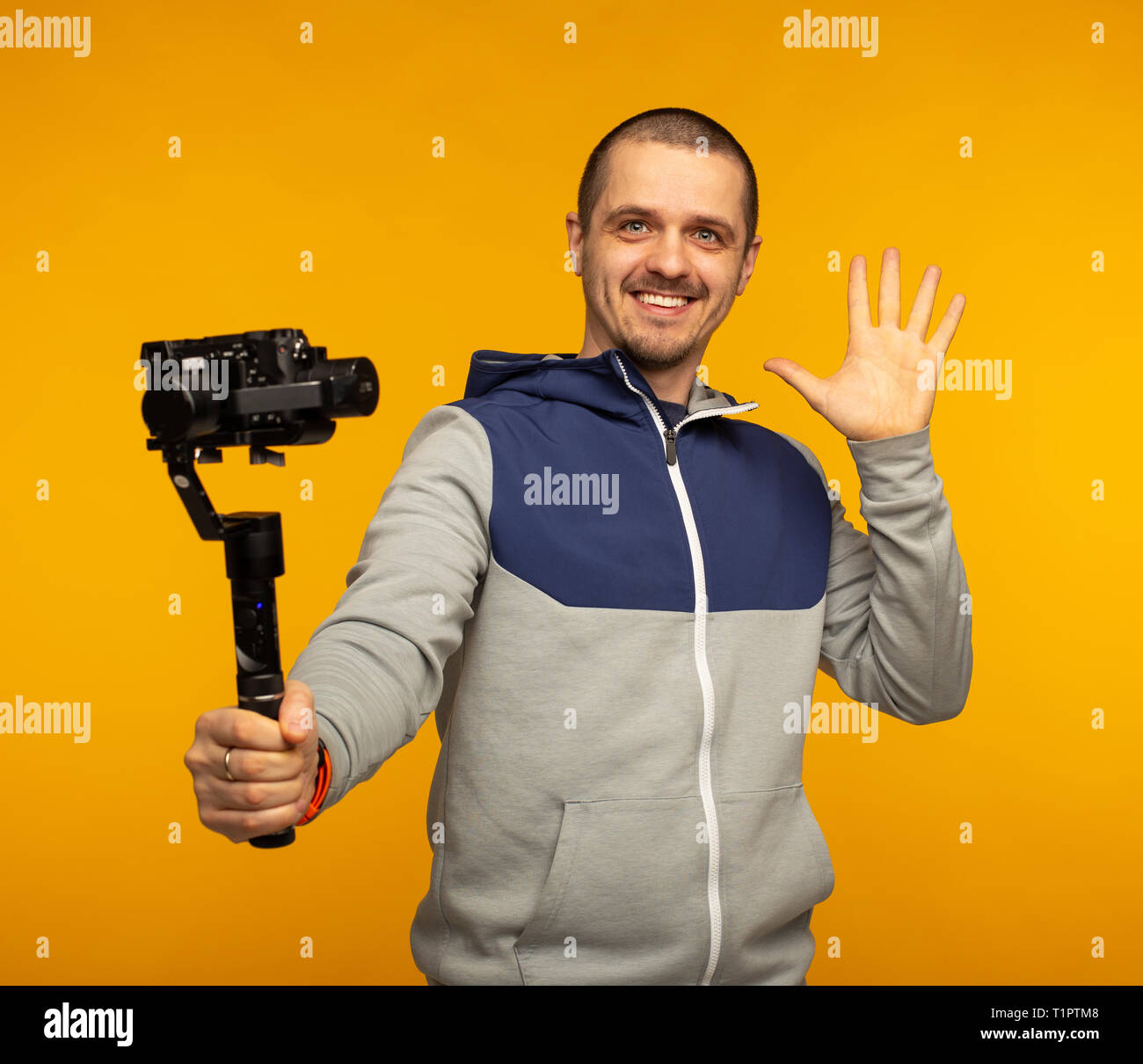 Vlogger homme ou la vidéo blogger tenir l'appareil photo sur l'appareil photo en souriant et cardan Banque D'Images