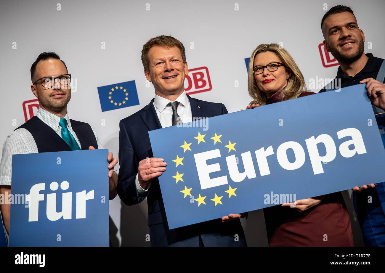 Berlin, Allemagne. Mar 28, 2019. Richard Lutz, président du conseil d'administration de Deutsche Bahn AG, est debout devant la conférence de presse de bilan d'une séance de photos avec les mots 'DB Bahn für Europa" entre les employés de chemin de fer (l-r Remco Crutzen, conducteur de train en provenance des Pays-Bas, Joanna Sobottka, chef de train à partir de l'Allemagne et Zuhal Nalbat à partir de l'Autriche). Crédit : Michael Kappeler/dpa/Alamy Live News Banque D'Images