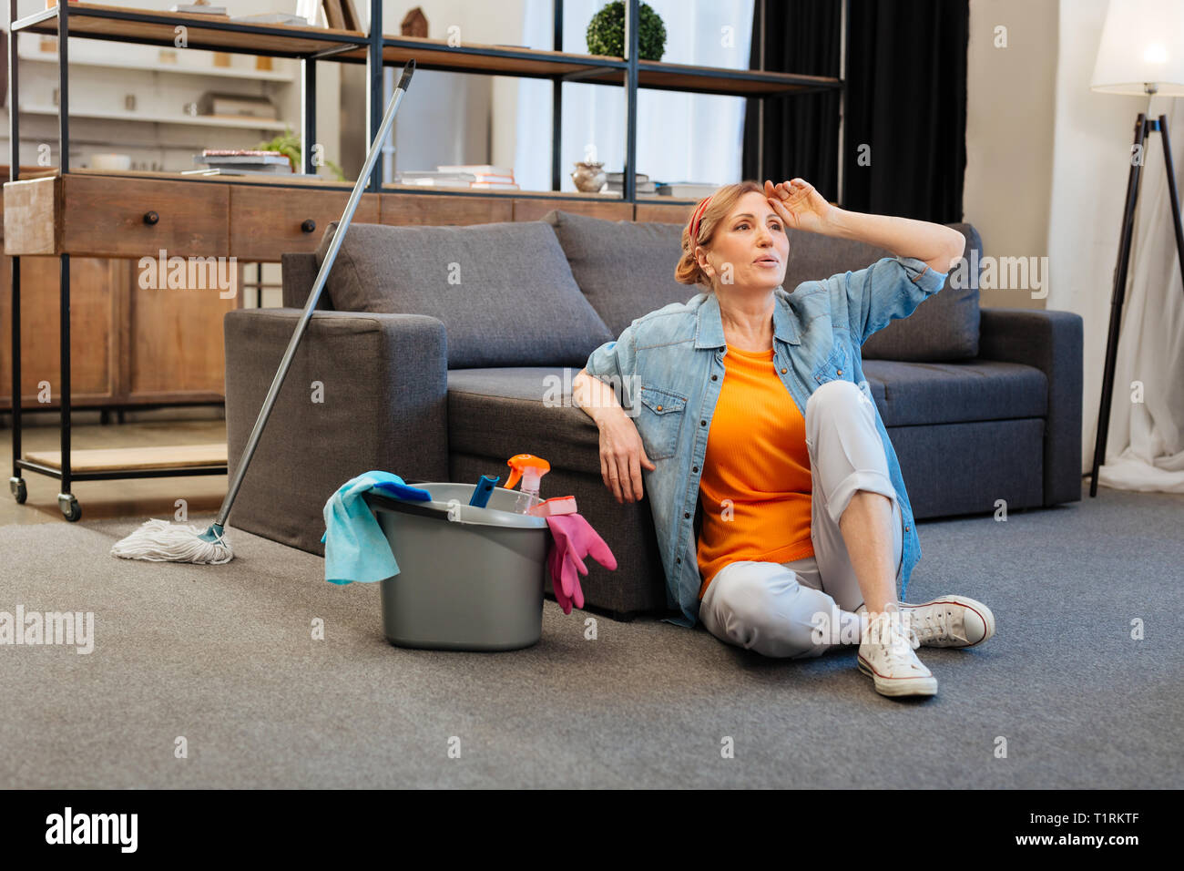 Fatigué et anxieux light-haired woman en t-shirt orange Banque D'Images