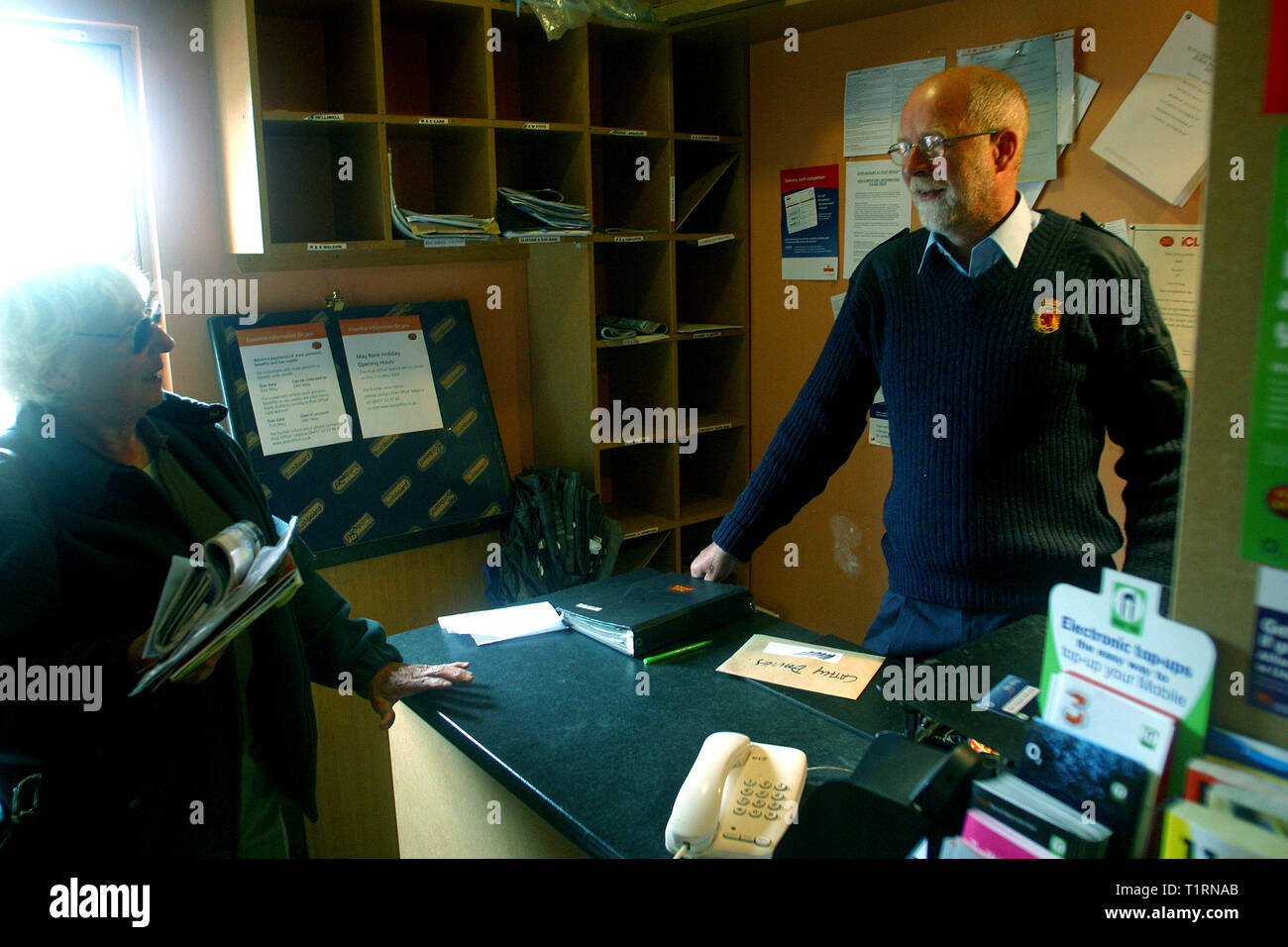 Postman John Cormack dans le minuscule bureau de poste à Galmisdale sur l'île de Eigg Hébrides à discuter avec un client. L'île de Eigg faisait partie d'une chaîne d'îles qui se trouvent de la côte ouest de l'Écosse et était accessible par un service de Lifeline en provenance du continent. Les résidents sur Eigg a organisé le rachat de l'île à la fin des années 1990 et s'il en a la communauté... Banque D'Images