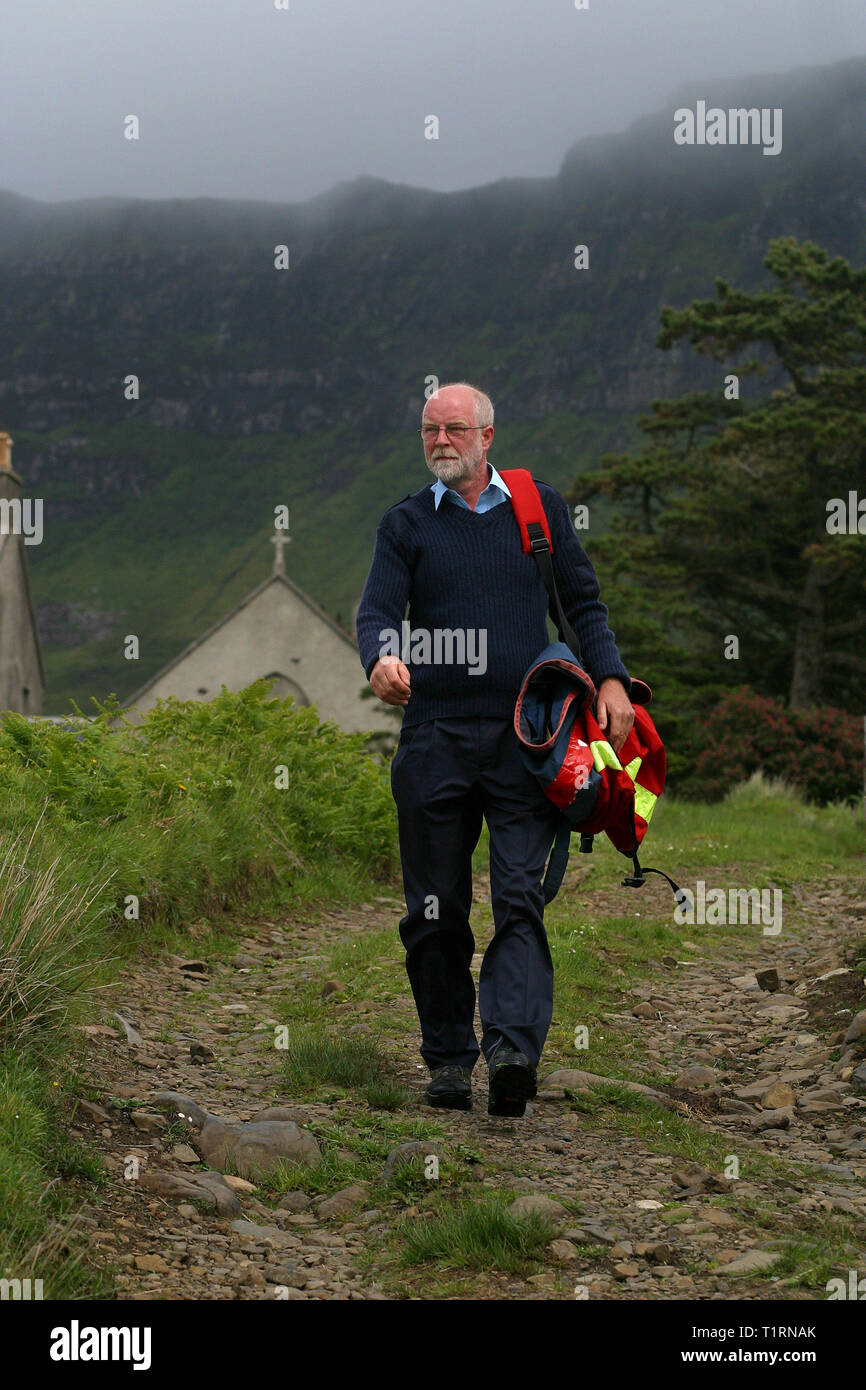 Postman John Cormack la livraison du courrier à Liag Bay sur l'île de Eigg des Hébrides. L'île de Eigg faisait partie d'une chaîne d'îles qui se trouvent de la côte ouest de l'Écosse et était accessible par un service de Lifeline en provenance du continent. Les résidents sur Eigg a organisé le rachat de l'île à la fin des années 1990 et s'il en a la communauté... Banque D'Images