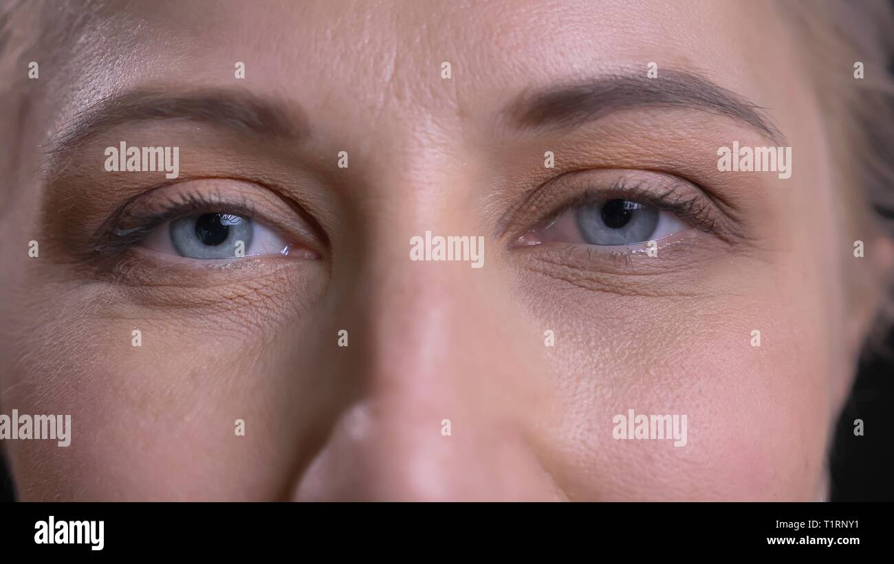 De jeunes pousses Gros plan femme caucasienne attrayant aux yeux bleus à la caméra à droite Banque D'Images