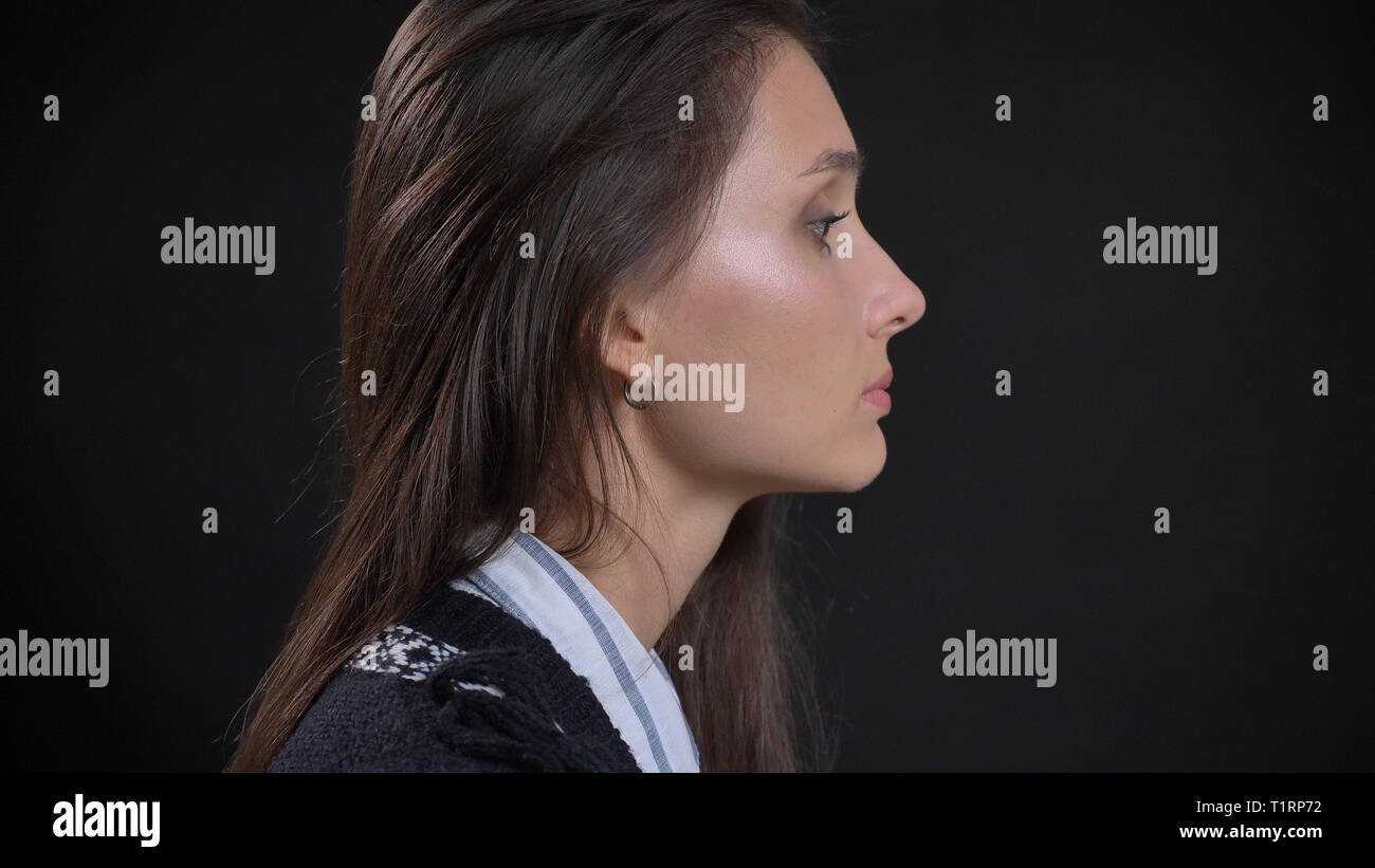 Vue côté gros plan portrait de jeune caucasien visage de femme avec des cheveux brun à l'avant avec l'arrière-plan isolé Banque D'Images