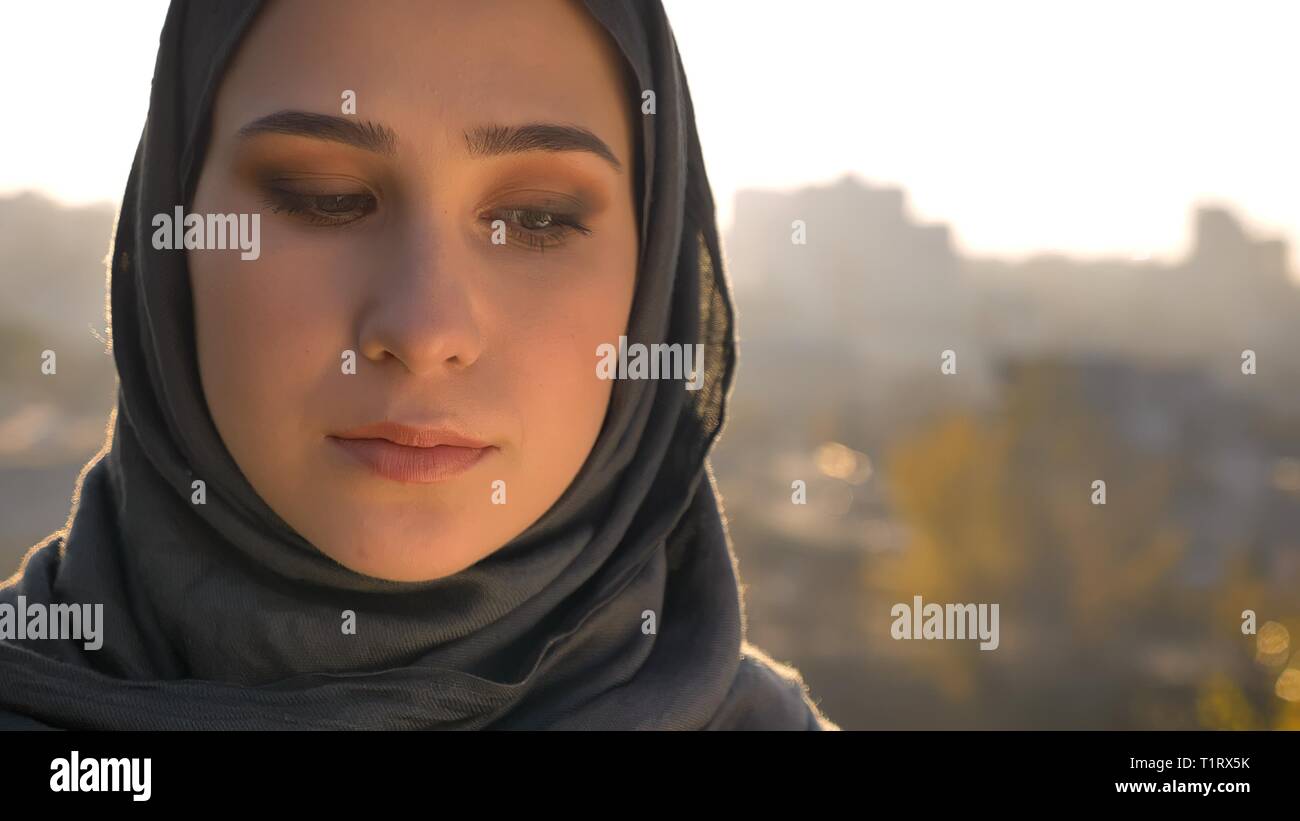 Closeup portrait de jeunes femmes musulmanes en hijab attrayant à la recherche vers le bas avec milieu urbain sur l'arrière-plan Banque D'Images