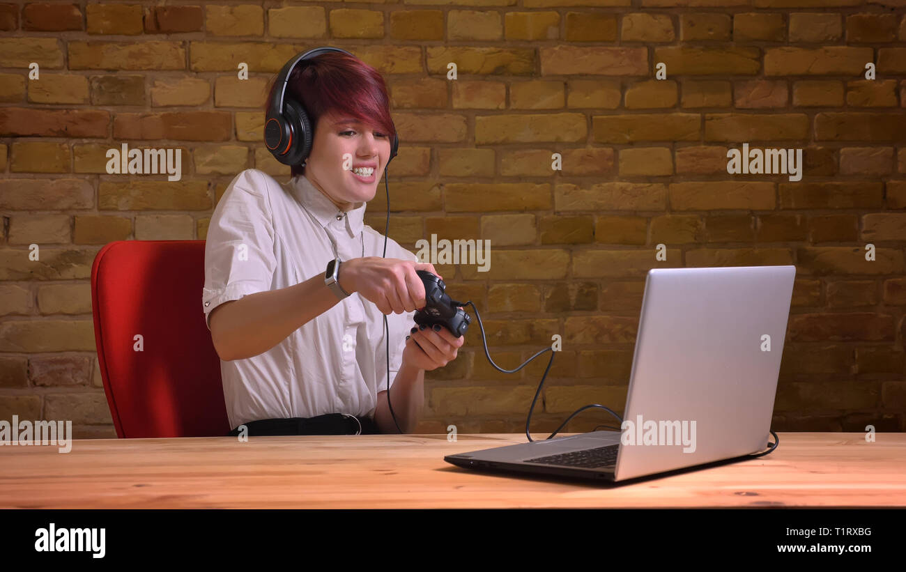 De jeunes pousses Gros plan jolie femelle hipster blogger vidéo de jeux vidéo à l'aide de la console de jeu sur l'ordinateur portable et le streaming en direct Banque D'Images