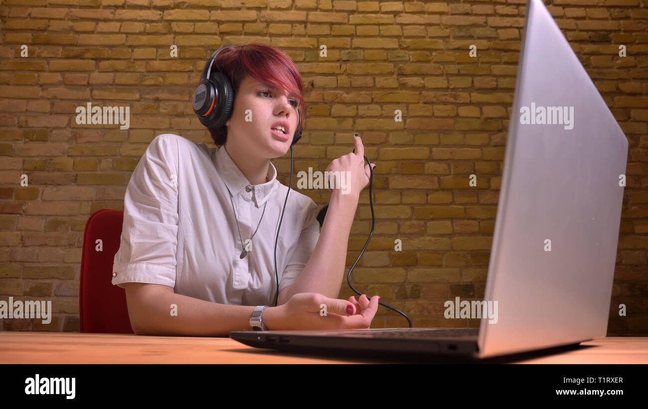 De jeunes pousses Gros plan young female video hipster blogger à jouer à des jeux vidéo sur l'ordinateur portable à l'aide de la console de jeu à défaut d'un niveau et d'être Banque D'Images