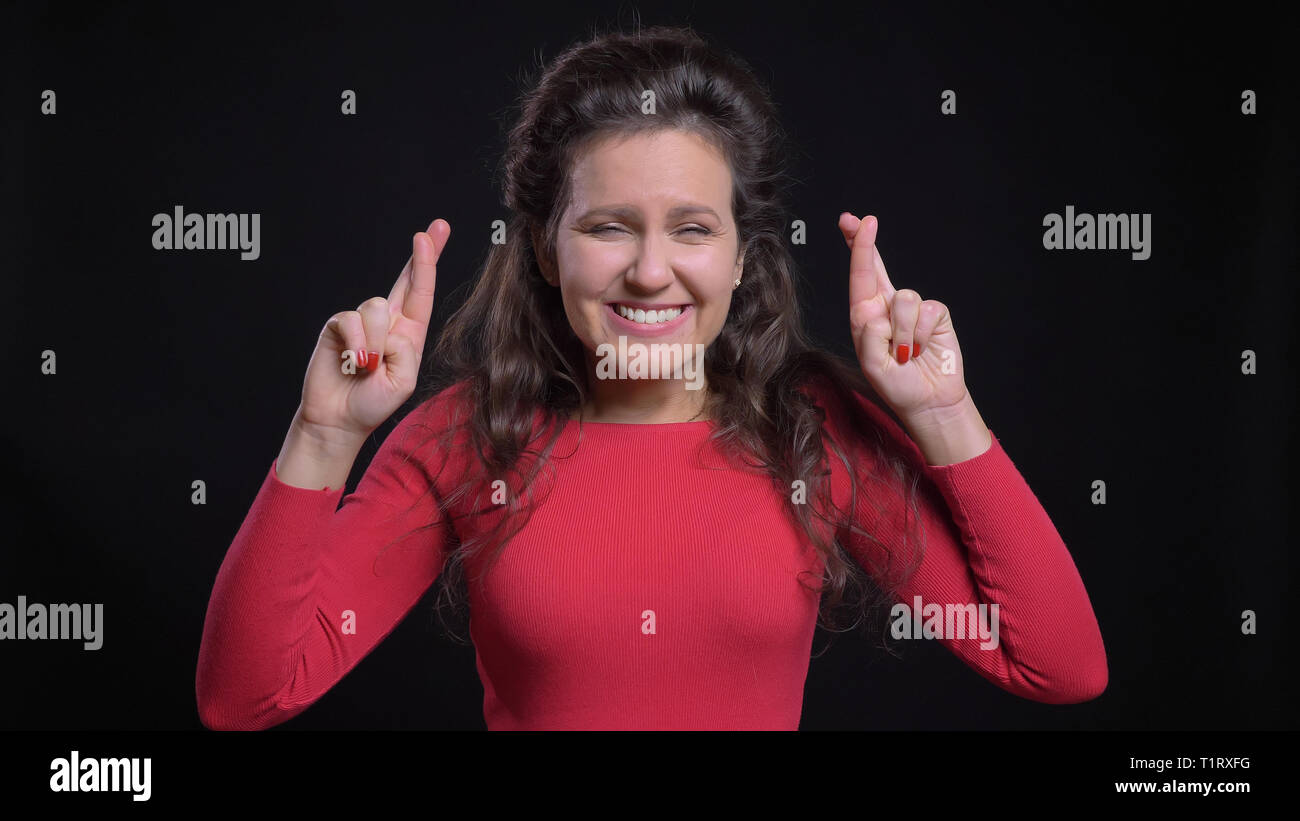 Closeup portrait of attractive middle-aged woman femme d'avoir ses doigts croisés dans l'anxiété et priant nerveusement devant la caméra Banque D'Images