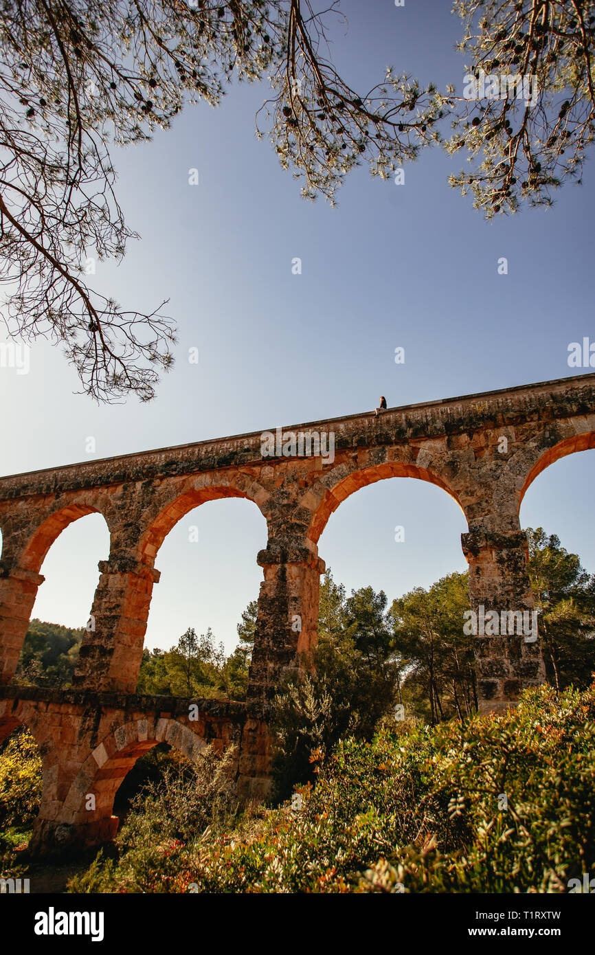 Aqueduc romain Pont del Diable à Tarragone, Espagne. Jeune femme rebelle assis sur le monument. Banque D'Images