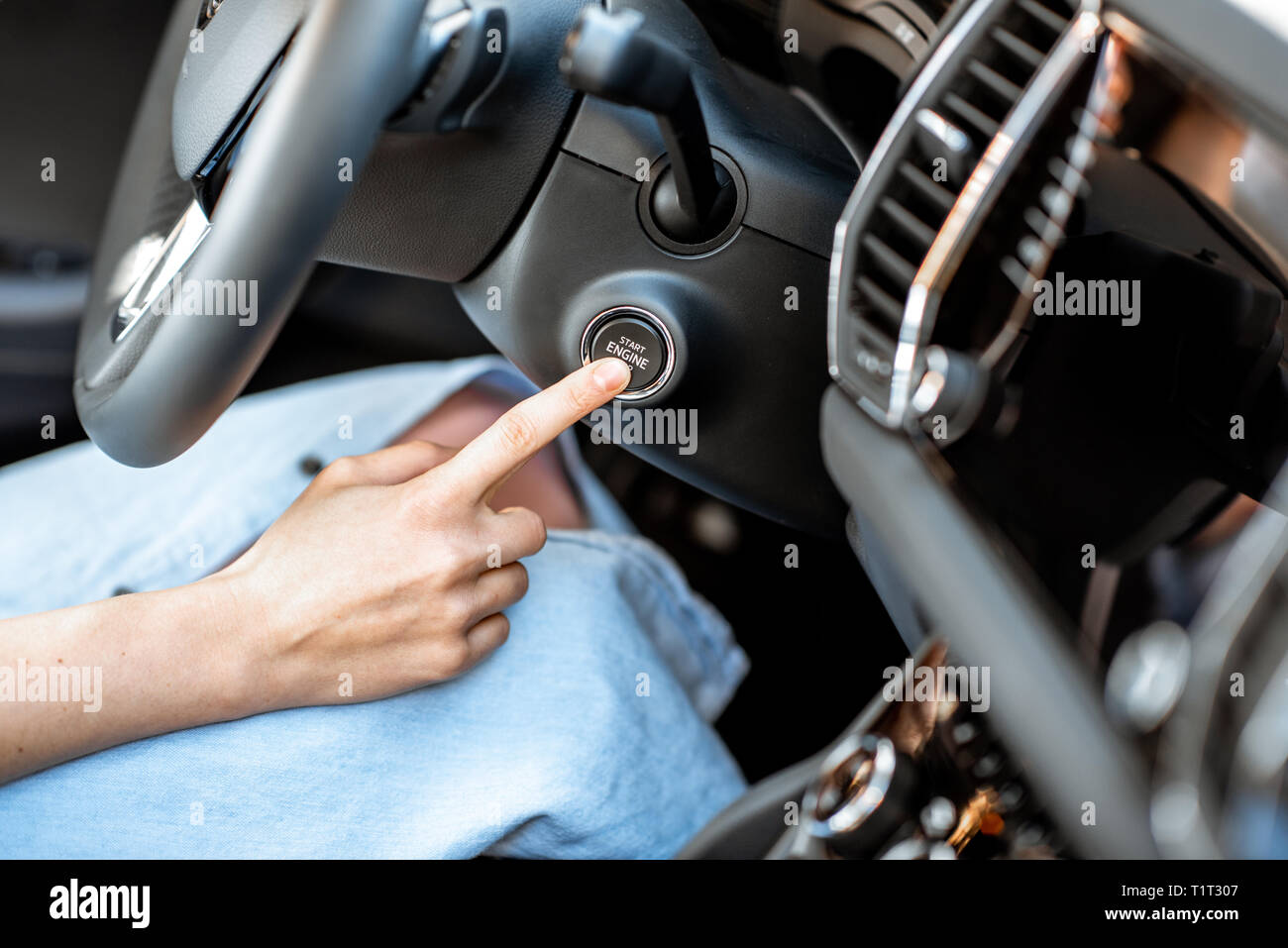 Démarrage moteur voiture femme avec bouton, vue rapprochée. Concept de voiture sans clé start Banque D'Images