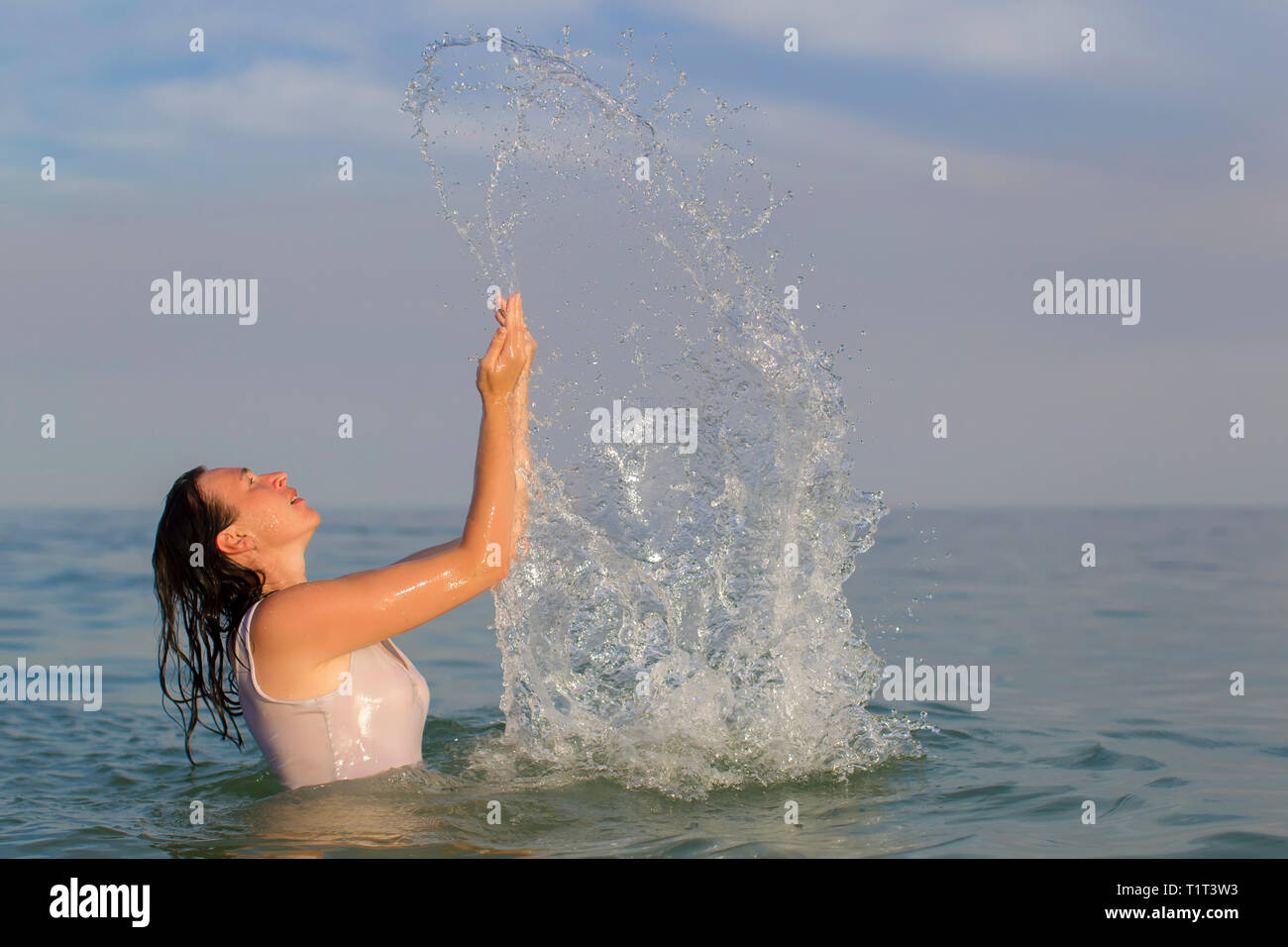 Femme d'âge moyen dans la mer avec jet d'eau. Banque D'Images