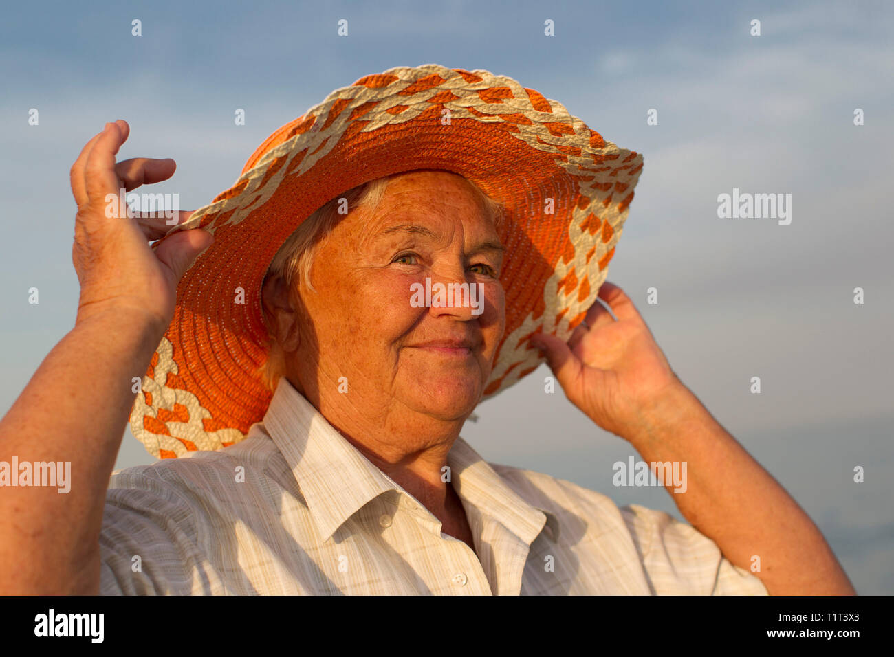 Belle femme âgée dans un chapeau sur le fond de la mer. Visage d'une vieille femme avec un sourire. Banque D'Images