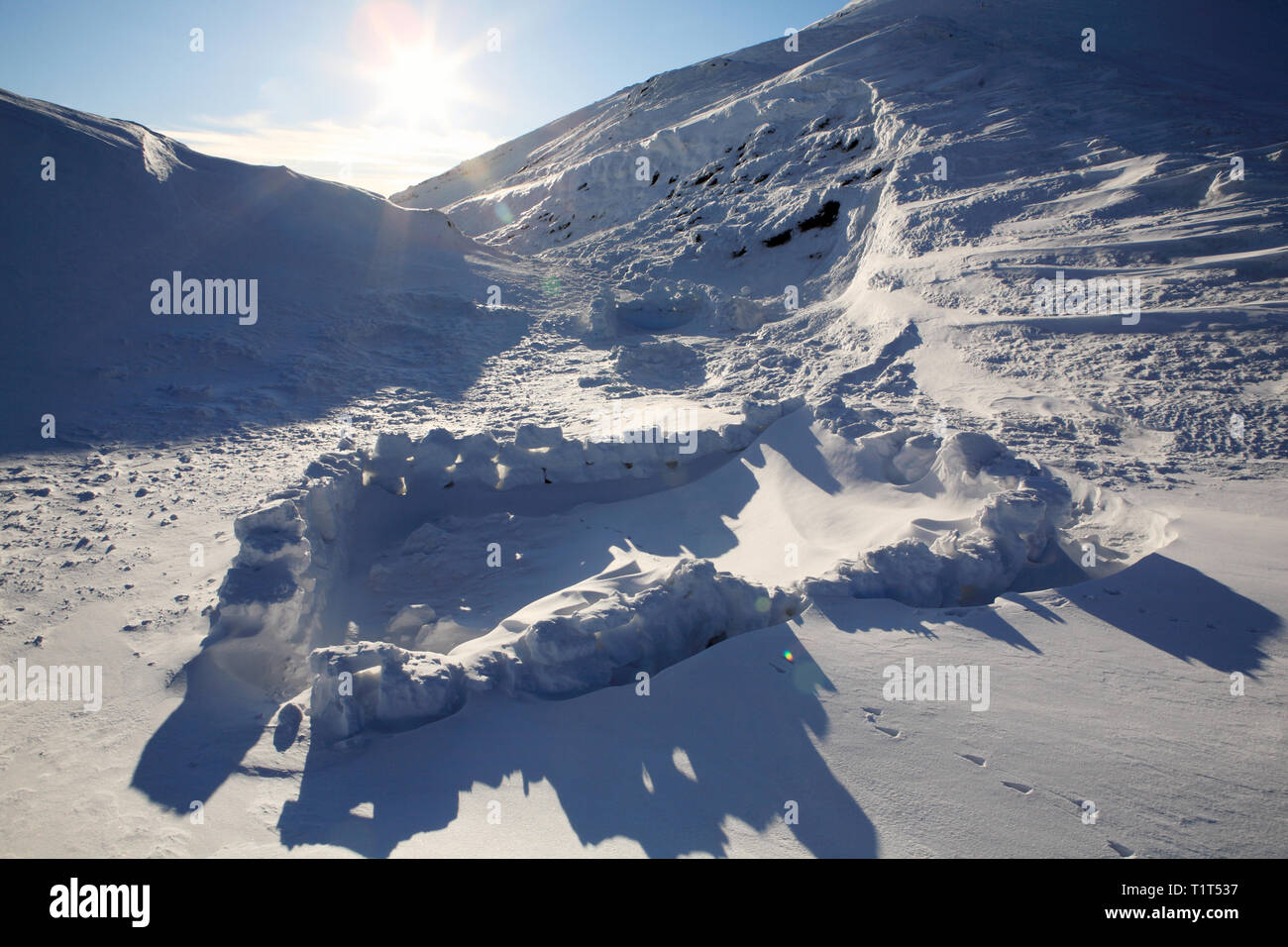 Mur de neige pour protéger la tente du vent Banque D'Images