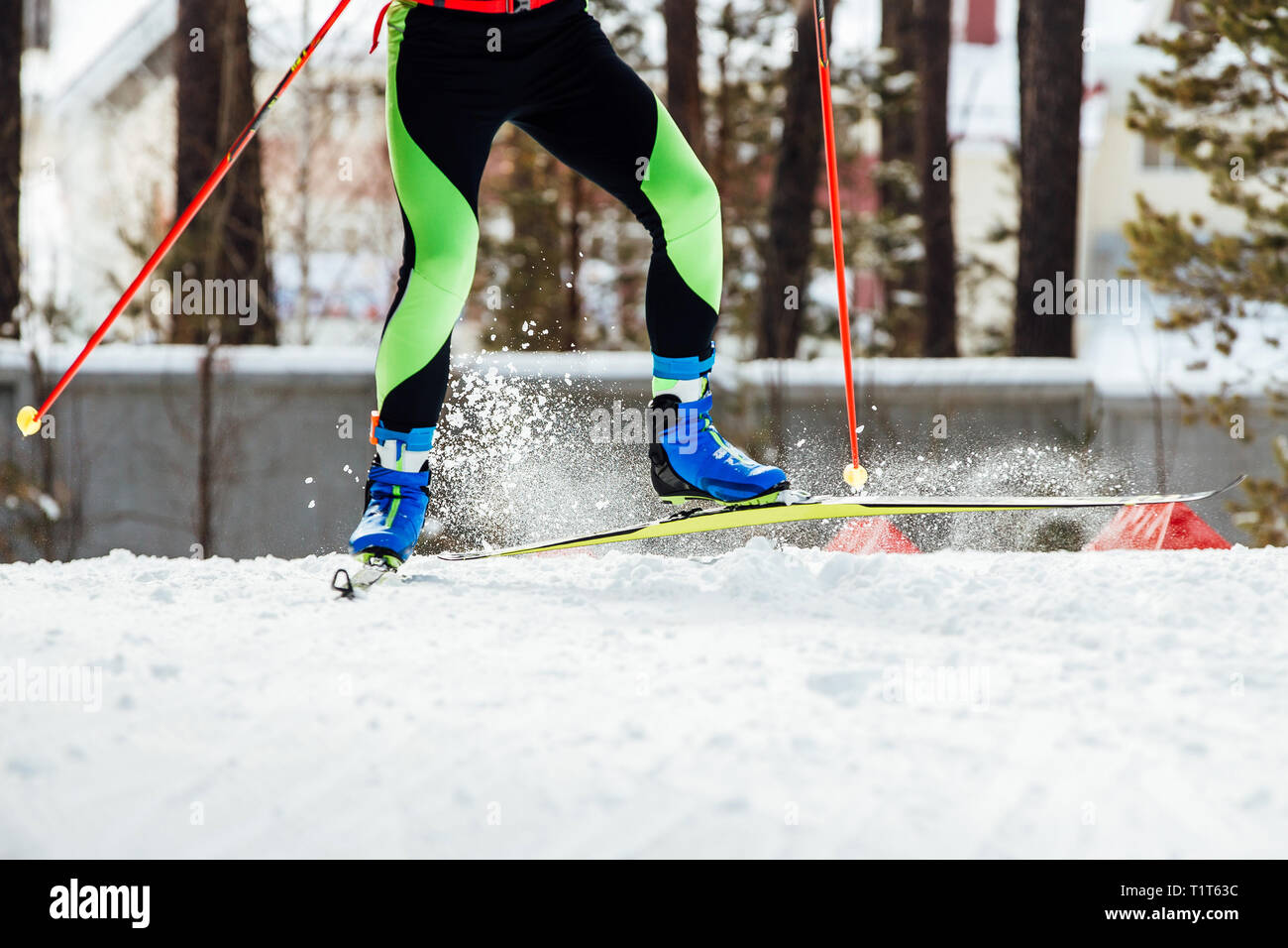 Pieds d'athlète skieur de pulvérisation sous la neige vole de skis et bâtons Banque D'Images
