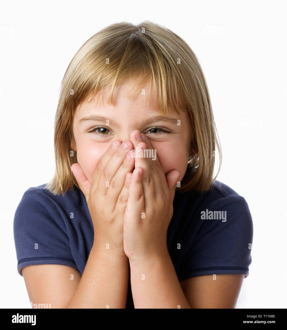 Blonde 7 ans rire avec les mains sur la bouche Banque D'Images