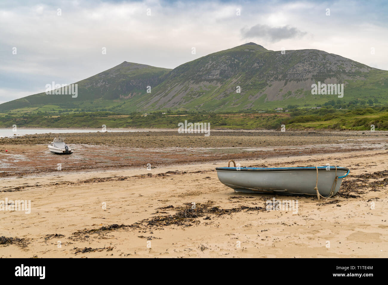 Sur le paysage gallois Llyn Peninsula - avec quelques bateaux sur la plage et Gyrn Goch en arrière-plan, vu dans Trefor, Gwynedd, Pays de Galles, Royaume-Uni Banque D'Images
