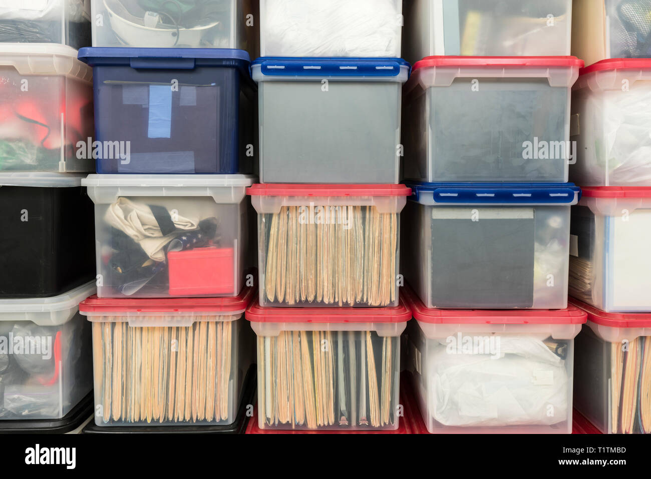 Boîtes de stockage de fichier en plastique empilés avec les dossiers, classeurs et articles divers. Banque D'Images