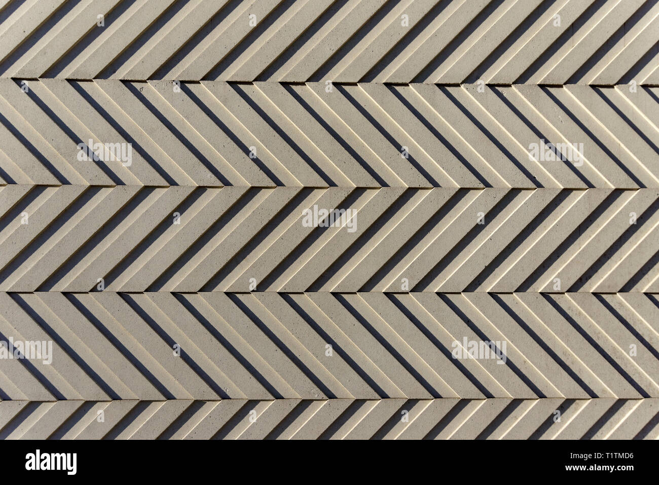 Libre de répéter en chevrons sur un placage de béton mur sur le côté d'un immeuble, illusion optique Banque D'Images