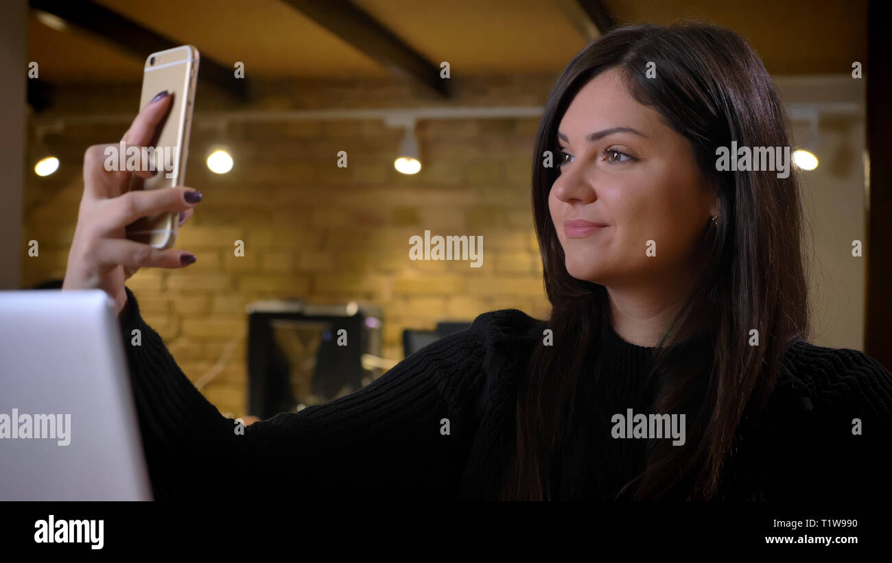 Un excès d'âge moyen de la femme faisant des selfies volontiers à l'aide de photos sur smartphone. Banque D'Images