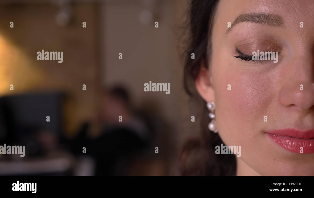 Demi-gros plan face à de jeunes pousses pretty caucasian femelle avec les yeux fermés à l'intérieur sur le lieu de travail Banque D'Images