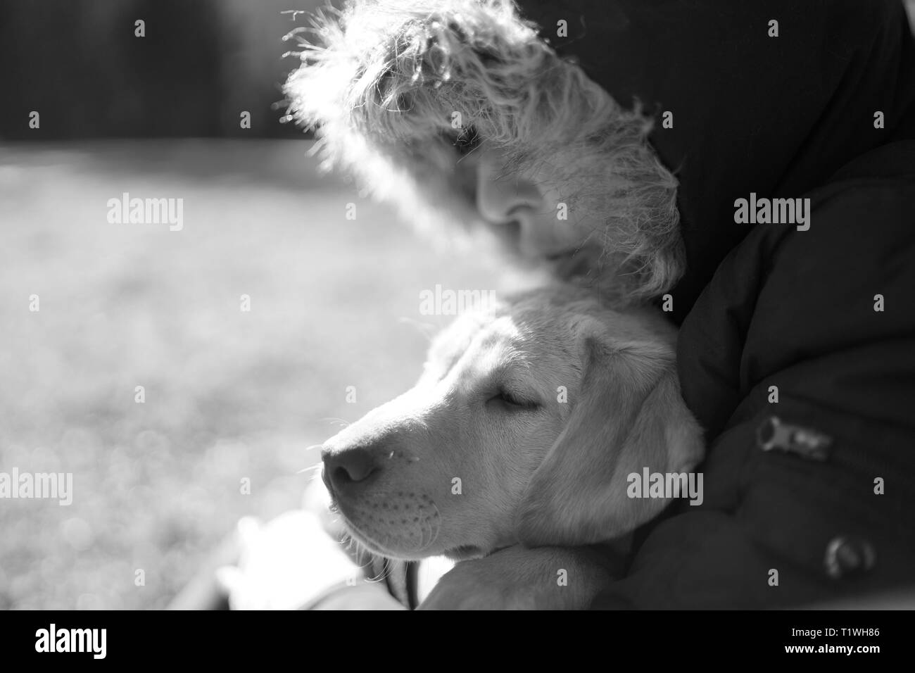 Une femme embrasse son labrador en hiver. Banque D'Images