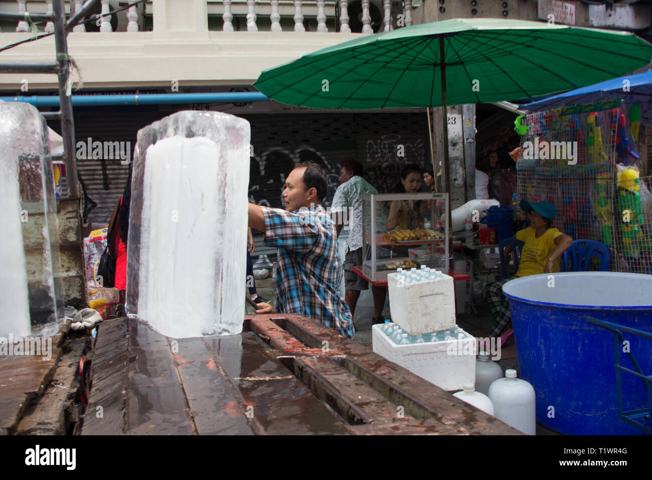 Travailleur thaïlandais s'occupe d'immenses blocs de glace à Khao San Road Bangkok, Thaïlande Banque D'Images