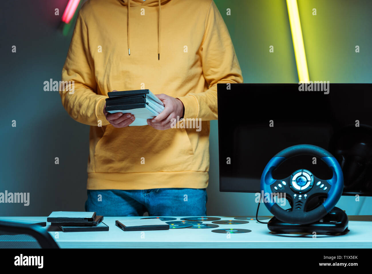 Portrait de l'homme debout et tenant les disques compacts avec jeux vidéo Banque D'Images